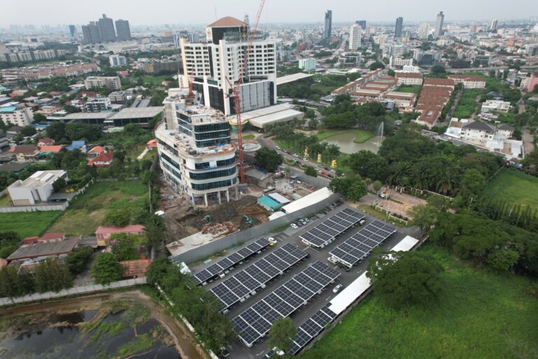 Aerial view of a construction site with solar panels in foreground, Bangkok