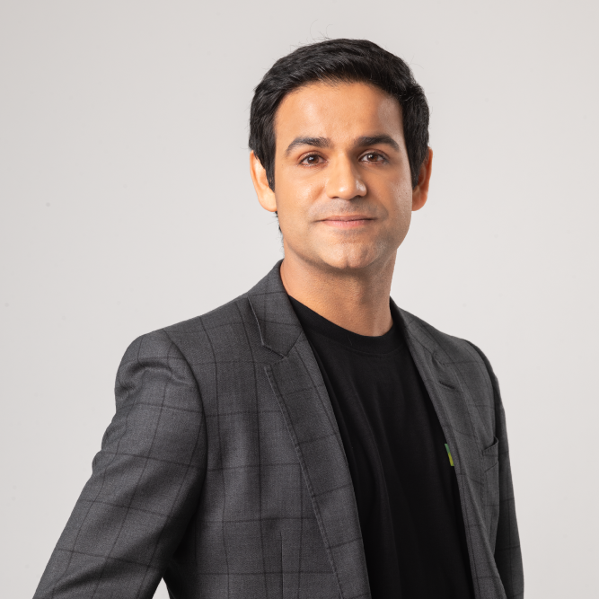 Man in a grey suit jacket over a black t-shirt