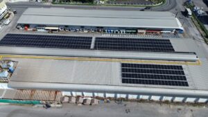 Solar panels installed on the roof of a large industrial building, likely for a trading and cold storage company.