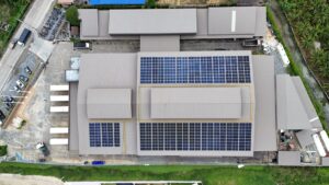 Aerial view of K-Fresh citrus farm with solar panels on rooftops.