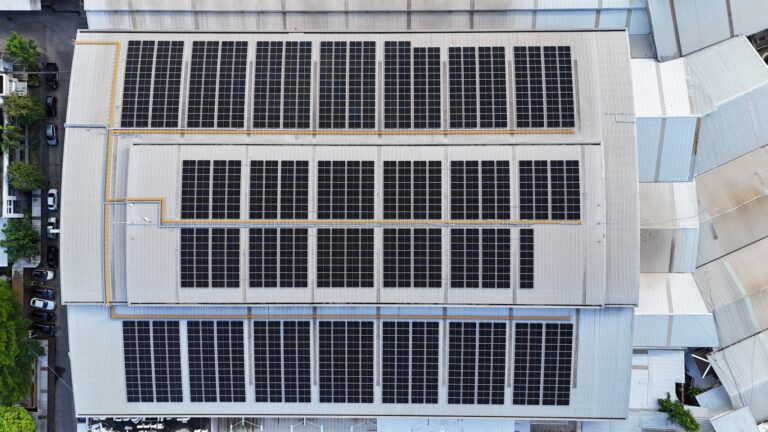 Aerial view of a large rooftop solar panel installation at Sak Thong (Thai) Co., Ltd.
